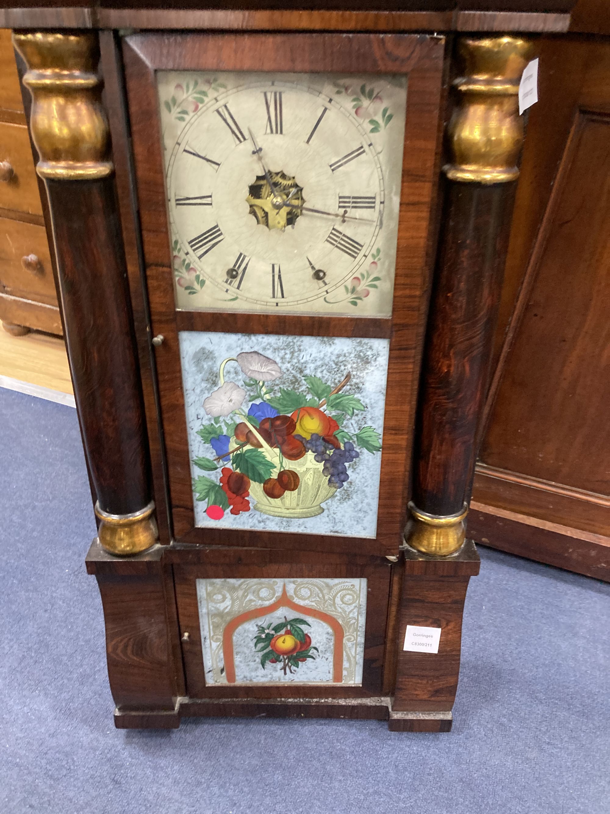 A 19th century American simulated rosewood wall clock, height 84cm, a 19th century inlaid wall clock and a mahogany pedestal cupboard